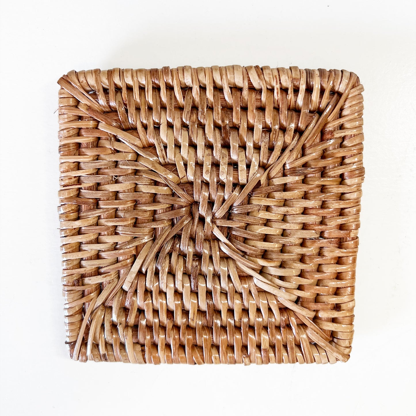 Top view of a set of eco-friendly, square coasters with intricate woven patterns.